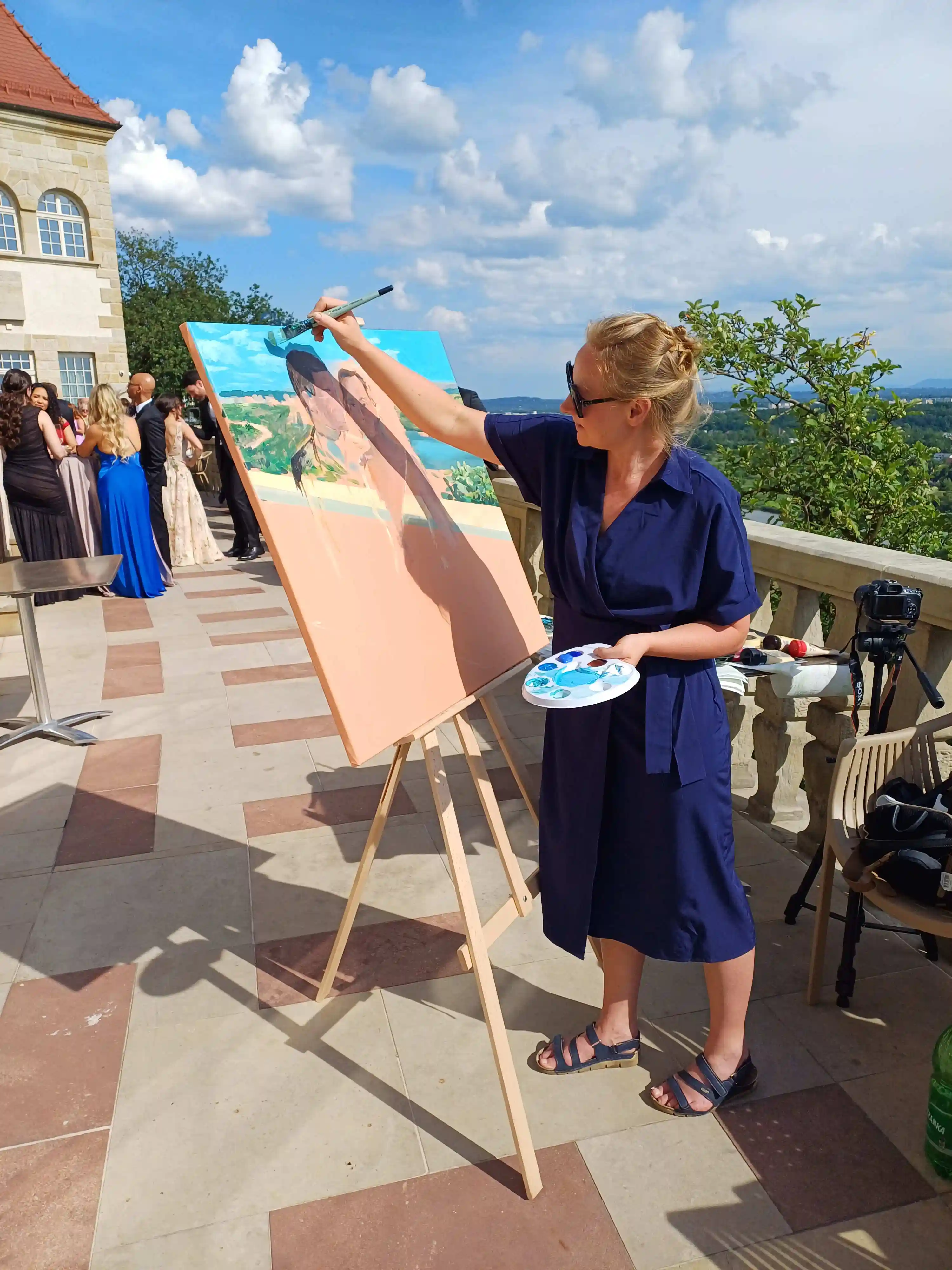 Jowita maluje obraz podczas wesela – sztaluga, malarka i goście weselni w tle